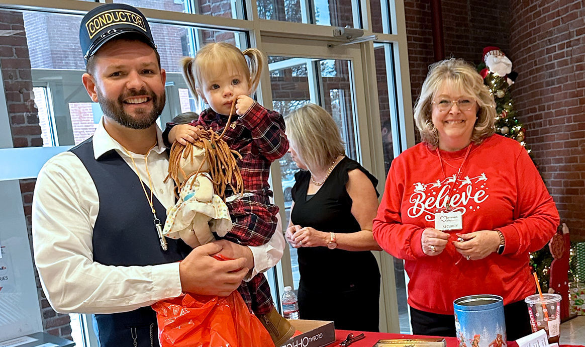 Retired MVCU team member Debee Herron-Nelan (far right) smiles with her son, Zach, and her grandkids while welcoming guests to the holiday party at MVCU's Lawrence corporate office.