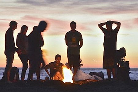 group of people around fire on beach